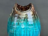 a blue vase that is sitting on a wooden table