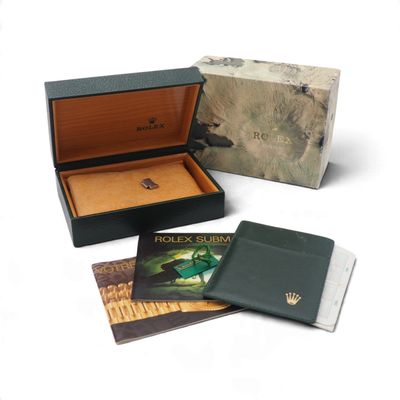 une boîte avec une montre à l'intérieur sur une surface blanche