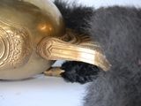 a black cat that is playing with a gold vase