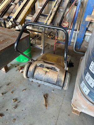 a machine that is sitting on the floor next to a pile of wood
