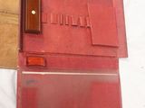 an old red case with a pen and a pencil inside of it