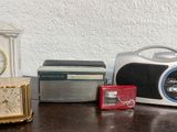 a clock, a radio, a clock, and a clock on a table