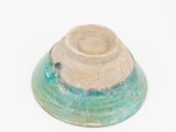 a blue and green bowl on a white surface