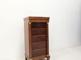 an image of a small wooden cabinet in a white room