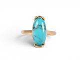 une bague en or avec une pierre turquoise au centre