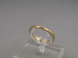 an image of a gold wedding ring on a clear acrylic stand
