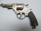 an old gun on a white surface with a black handle
