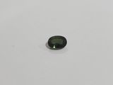 a green tourmaline gems on a white surface