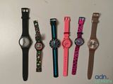 plusieurs montres différentes sont alignées sur une surface blanche