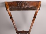 une vieille chaise en bois avec un dossier et une assise sculptés