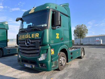 deux camions verts garés l'un à côté de l'autre sur un parking