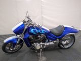 a blue motorcycle that is parked on a black floor