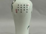 un vase blanc orné d'inscriptions asiatiques, posé sur une table