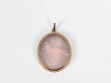 a close up of a gold locke with a pink stone in the center