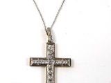un gros plan d'une croix suspendue à un collier, sur fond blanc
