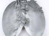 a silver plate with pine cones and leaves on it