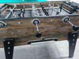 a foosball table with a pool in the background