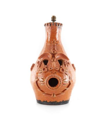un vase marron surmonté d'un nichoir