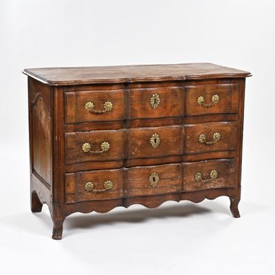 une vieille commode en bois dont les tiroirs sont ornés de ferrures en laiton