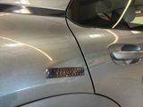 a silver car with a sticker on the side of it