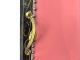 a close up of a pink dress with a black and gold trim