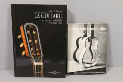 deux livres posés sur une table, avec une guitare devant eux