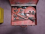 une boîte rouge contenant des outils, posée sur une surface violette