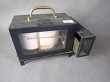 un petit micro-ondes noir avec une porte en verre et une poignée en métal