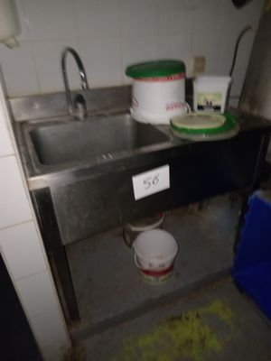 un évier sale dans une cuisine sale, avec de la vaisselle sale