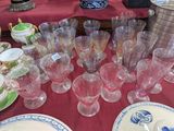 de nombreux verres et assiettes posés sur une table recouverte d'une nappe rouge