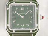une montre verte exposée sur une surface blanche
