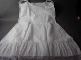 a white dress hanging on a hanger next to a pair of shoes