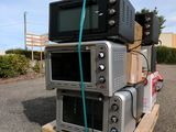 three microwaves stacked on top of each other on a pallet