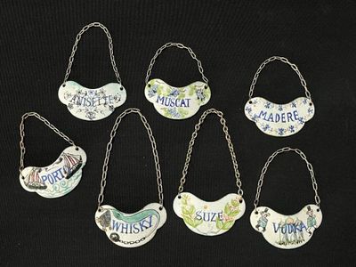 six different kinds of bird ornaments hanging from chains on a black surface