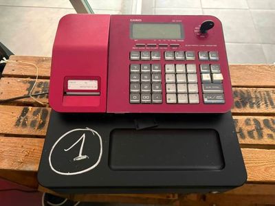 une calculatrice rose posée sur une table en bois