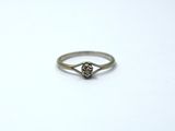 a close up of a diamond ring on a white surface