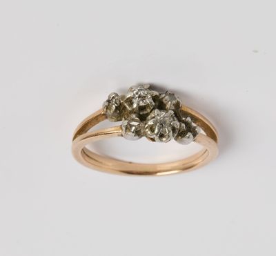 un gros plan d'une bague en or sertie d'un bouquet de diamants