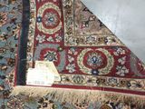 a red and blue rug on the floor with a tag on it