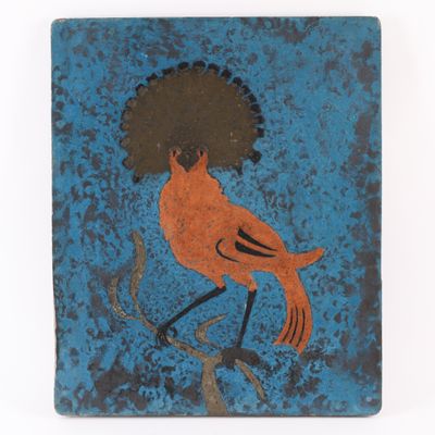 un oiseau orange au bec noir sur fond bleu