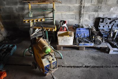 un tas d'outils dans un garage, à côté d'une étagère