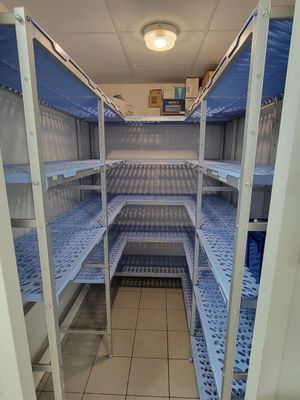 une longue étagère au milieu d'une pièce, avec des tablettes bleues