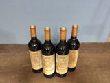 three bottles of wine sitting on top of a wooden table
