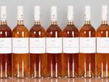 six bottles of wine are lined up in a row on a table