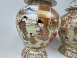 two vases with asian designs on them sitting on a table