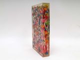 brightly colored lollipops in a clear box on a white surface