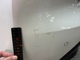 a hand that is holding a remote control near a white car