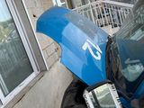 a blue motorcycle parked outside of a building with its hood open