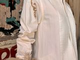 a mannequin dressed in a white shirt and beige pants