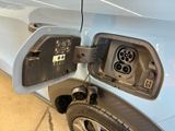 a blue car that has an electric charger attached to it