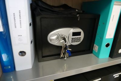a safe box on a shelf with a bunch of folders